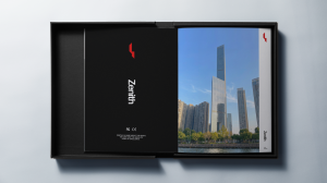 An open black presentation box containing a Zenith-branded book and a printed photograph of a glass skyscraper.