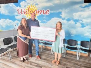 TST A Divsion of Fisher Barton presents check to Sunshine Place Food pantry
