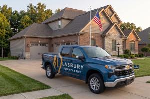 Lasbury Security & Fire service vehicle parked in a residential driveway.