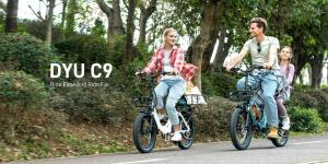 Riders using DYU C9 foldable electric bikes on a paved path.