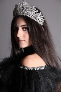 Portrait of songwriter Tamara Mechael wearing a jeweled crown and black attire.