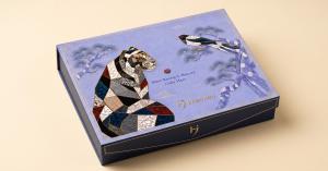 The Naru Ham sample box from Hannaru, its lid decorated with a mother-of-pearl najeon mosaic tiger and magpie in the Korean folk painting tradition, used by wholesale buyers to test products from multiple Korean cosmetics brands in one shipment.