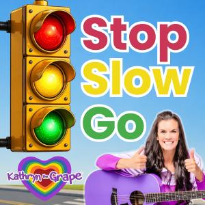 STOP SLOW GO album cover by Kathryn the Grape, featuring a colorful red, yellow, and green traffic signal alongside the words “Stop Slow Go,” with Kathryn smiling, giving two thumbs up, and holding a purple guitar against a bright blue background. The sig