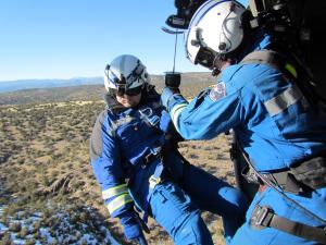 P1AR instructors completing live flight training with rescue specialist in the doorway of the helicopter