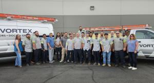 Vortex Doors Salt Lake City team of commercial door technicians standing in front of Vortex service vans in Utah