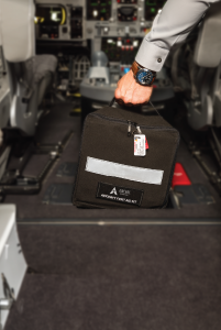 Pilot retrieving an Aircare International First Aid Kit onboard a business aircraft.