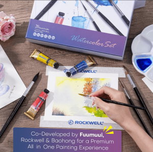 Artist painting with a FUUMUUI watercolor brush alongside ROCKWELL watercolor paints and BAOHONG watercolor paper from the collaborative set.