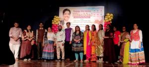 Group photo of community members celebrating Hitenbhai’s birthday on stage.