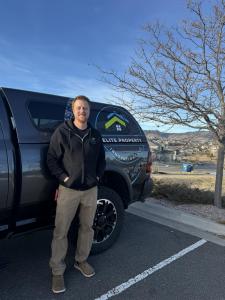 Jacob Long, owner of Elite Property Innovations, standing in front of the company's service truck in Westminster, Colorado
