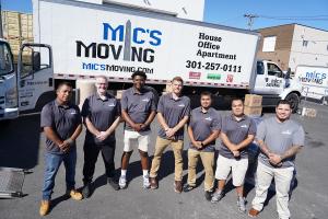 Mic’s Moving team preparing items for transport beside a moving truck.