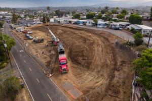 Aerial view of the Caritas Village – Vista construction site showing the cleared and graded property, construction equipment, and surrounding Vista neighborhood.
