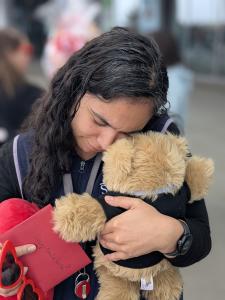 Woman holding a weighted therapeutic Comfort Cub after experiencing grief and loss.