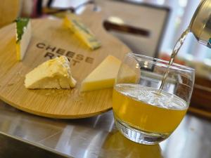 Cheese served on a Cheese Riot board with a drink