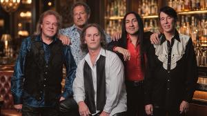 The guys of Already Gone, a Houston-based Eagles tribute, in a friendly, relaxed group pose with a slightly out-of-focus upscale bar in the background.