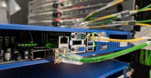 Close-up of a blue dedicated server chassis connected with network cables in a data center rack.