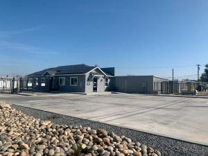 Exterior view of the main rental office and gated entrance security fence at Freedom Storage Inc. in Visalia, California.