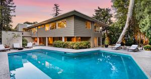 Mid-century modern house with pool at twilight.