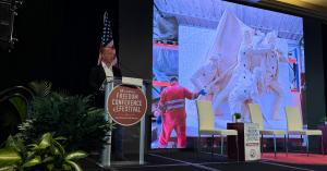 Sabin Howard speaks at the Steamboat Institute’s 18th Annual Freedom Conference in Beaver Creek, Colorado, with his National World War I Memorial sculpture projected behind him.