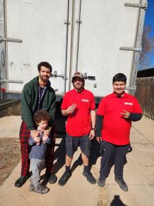 Fatboy Slims Moving Company crew in red uniforms in front of a moving truck in Colorado Springs