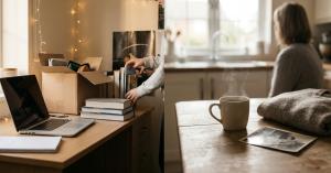 Split image of a student unpacking dorm boxes beside a laptop, and a parent sitting quietly with tea and a photo, showing both sides of the freshers week transition