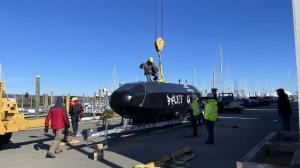 CET team members use an overhead crane to prepare the HADALUS autonomous underwater vehicle for launch.