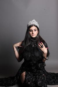 Songwriter Tamara Mechael wearing a black couture gown and jeweled crown in a dramatic portrait. Mechael wrote the lyrics for "Home (Aramaic)," the closing movement of the opera album Remembrance.