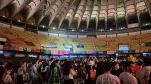 4.800 young people celebrating with their organisation flags in a stadium with yellow chairs