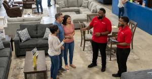 American Freight team members assist customers shopping for furniture and mattresses inside one of the retailer’s warehouse-style stores.