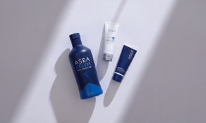ASEA Redox Supplement, ASEA RENU28, and ASEA RedoxGOLD laying flat together on a white surface in a sliver of sunlight.