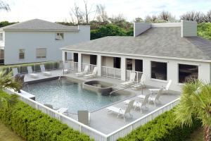 Rendering of a resort-style pool and spa beside a clubhouse with lounge chairs.