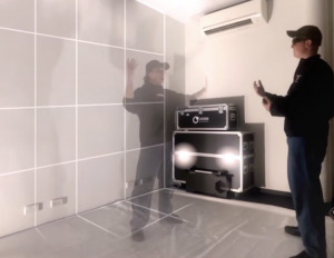 A man standing in front of a hologram of another person