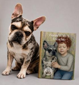Photo of Archi the dog posing with his book in the H.A.K. Heroes series, "Focus With a Frenchie"