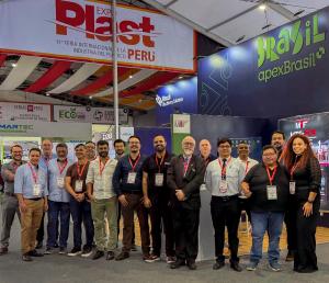 Un grupo de ejecutivos posa para una foto en el stand de Brazil Machinery Solutions durante Expoplast 2026, en Lima, Perú. En el centro y a ambos lados, hombres y mujeres se encuentran frente al espacio brasileño. Al fondo, se observan la identificación d