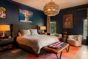 Blue Daze Designs pairs dark walls with collected artwork, sculptural lighting and layered textiles to create a sophisticated, inviting bedroom.