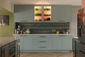 Custom cabinetry, statement tile and a playful color palette bring personality to this cocktail area designed by Blue Daze.