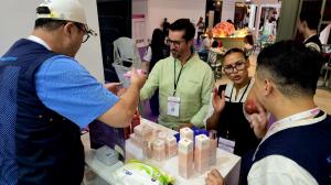 Hannaru sales team member handing a Korean beauty sample to a buyer testing product at BeautyEurasia 2026 in Istanbul