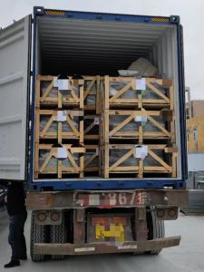 Wooden crates stacked and secured inside the open end of a shipping container.
