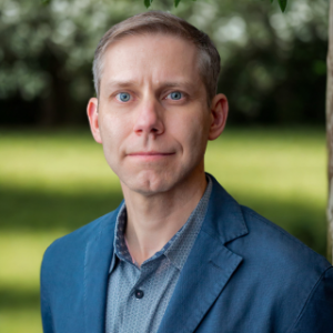 Headshot of Chris Maddocks, Senior Vice President of Digital at Avalon, wearing a blue blazer and collared shirt outdoors.