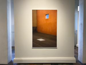 An image of a large scale photograph, southwest architecture wall, with a small opening and a cloud