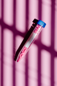 Pink vitamin supplement capsules in a tube, representing personalized nutrition support