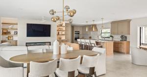Remodeled Winter Park great room with a round dining table, brass chandelier, white oak kitchen island and fireplace wall