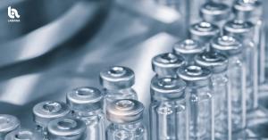 Close-up of pharmaceutical vials on a manufacturing line with the Labiana logo in the upper-left corner.
