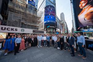 CB Insights employees gathered in Times Square in front of the Nasdaq tower displaying the CB Insights logo.