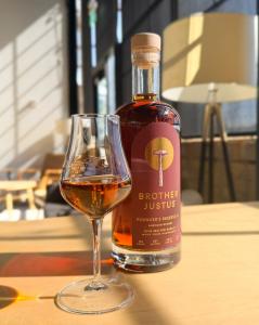 Brother Justus whiskey bottle beside a pour of whiskey