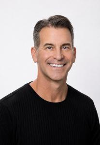Portrait of Jim Parrish wearing a black sweater against a light background.
