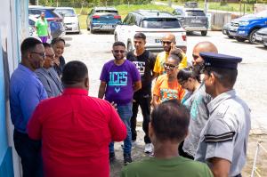 Members of the 1st Choice Family Services team stand in a group with a police officer during a community outreach in Trinidad.