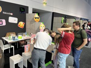 A family gathers at the Dr.Look Ai booth at IFA 2026 while a team member demonstrates the AI Learning Camera, with Dr.Look Ai branding and colorful displays in the background.