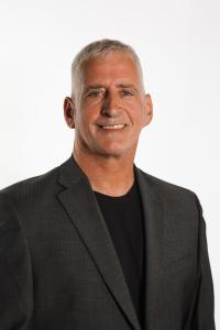 Photo of Omnisient CEO and co-founder Jon Jacobson wearing a black shirt and dark grey jacket