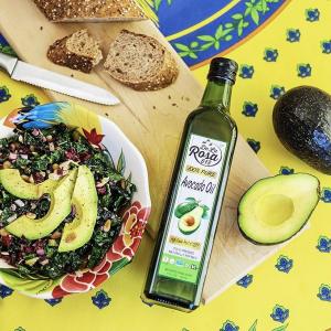 De La Rosa 100% Pure Avocado Oil bottle beside fresh avocados, whole-grain bread, and an avocado kale salad
