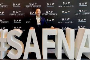 SUSTAERO CEO Keith Gillard behind a giant 3D sculpture reading #SAFNA.